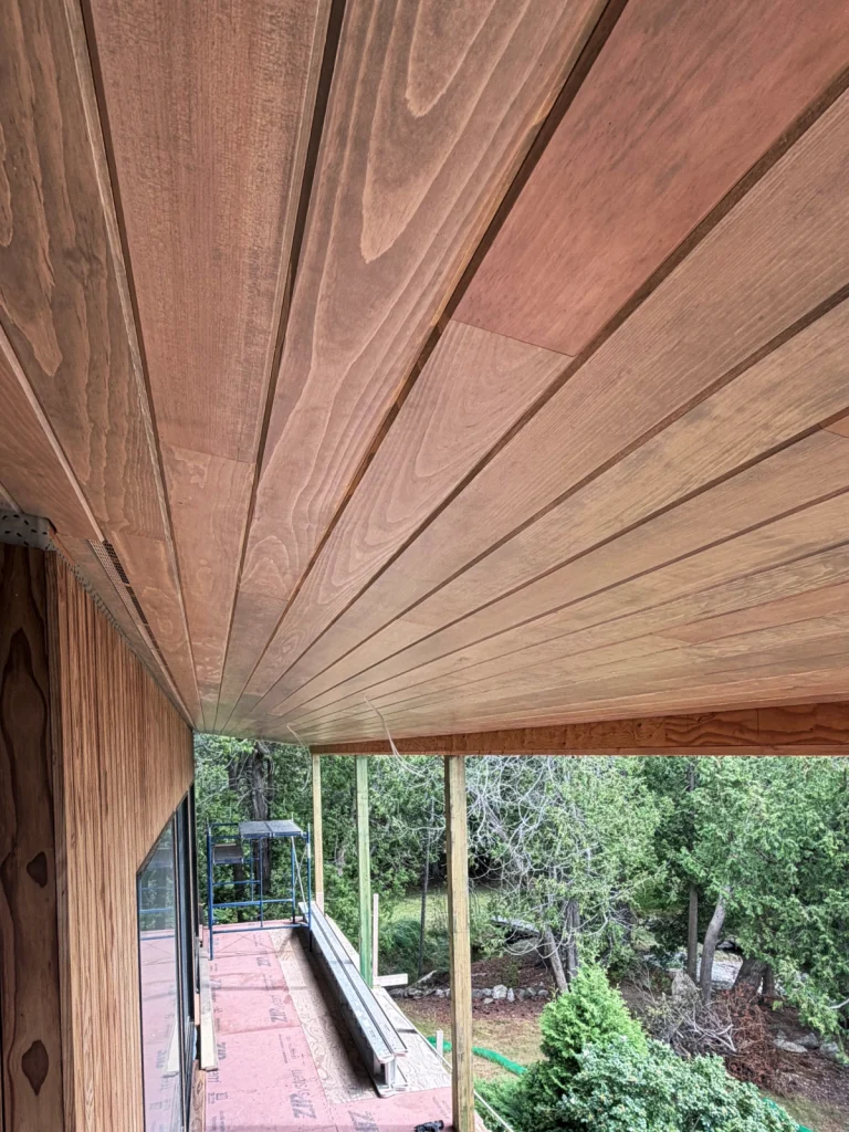 Tongue and goove pine ceiling installed under an exterior roofline extending over a deck showcasing an impactful home improvement