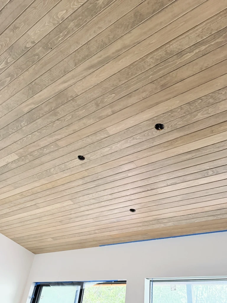 Tongue-and-groove pine ceiling installation in a residential interior showcasing dramatic home improvement